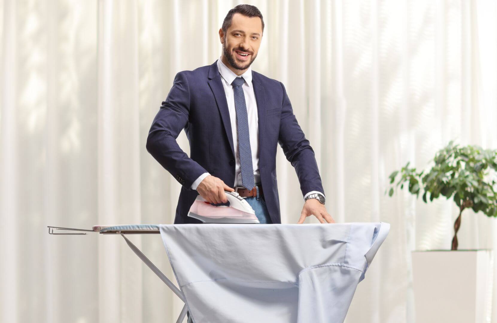 Un homme en costume repasse une chemise